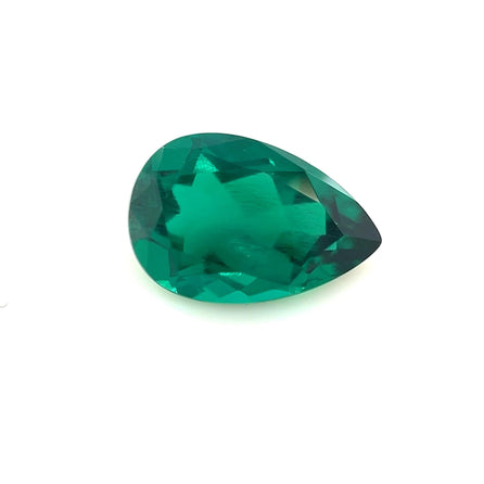 The 12.0x8.0 Exceptional Pear Zambian Color Lab Created Emerald is shown against a plain white background, highlighting its vivid green color and brilliant, reflective surface.