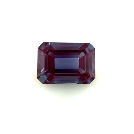 A 7.0x5.0 Exceptional Emerald Lab Created Alexandrite gemstone, rectangular in shape with rich purple and blue hues, is displayed on a plain white background.