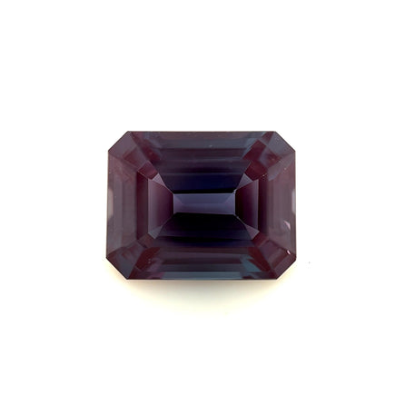 A 10.0x8.0 exceptional emerald-cut lab created Alexandrite with deep purple hues and sharp facets is displayed against a plain white background.