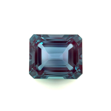 A 12.0x10.0 emerald-cut, rectangular lab-created Alexandrite with beveled corners and a transparent, reflective blue surface, displayed on a white background for exceptional clarity and brilliance.