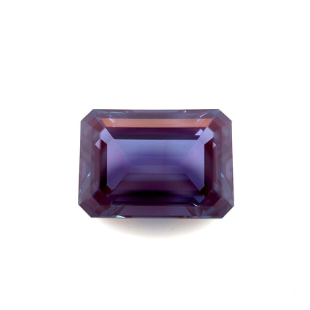 The 14.0x10.0 Exceptional Emerald Lab Created Alexandrite features an emerald shape with deep purple and blue hues, showcased against a white background.