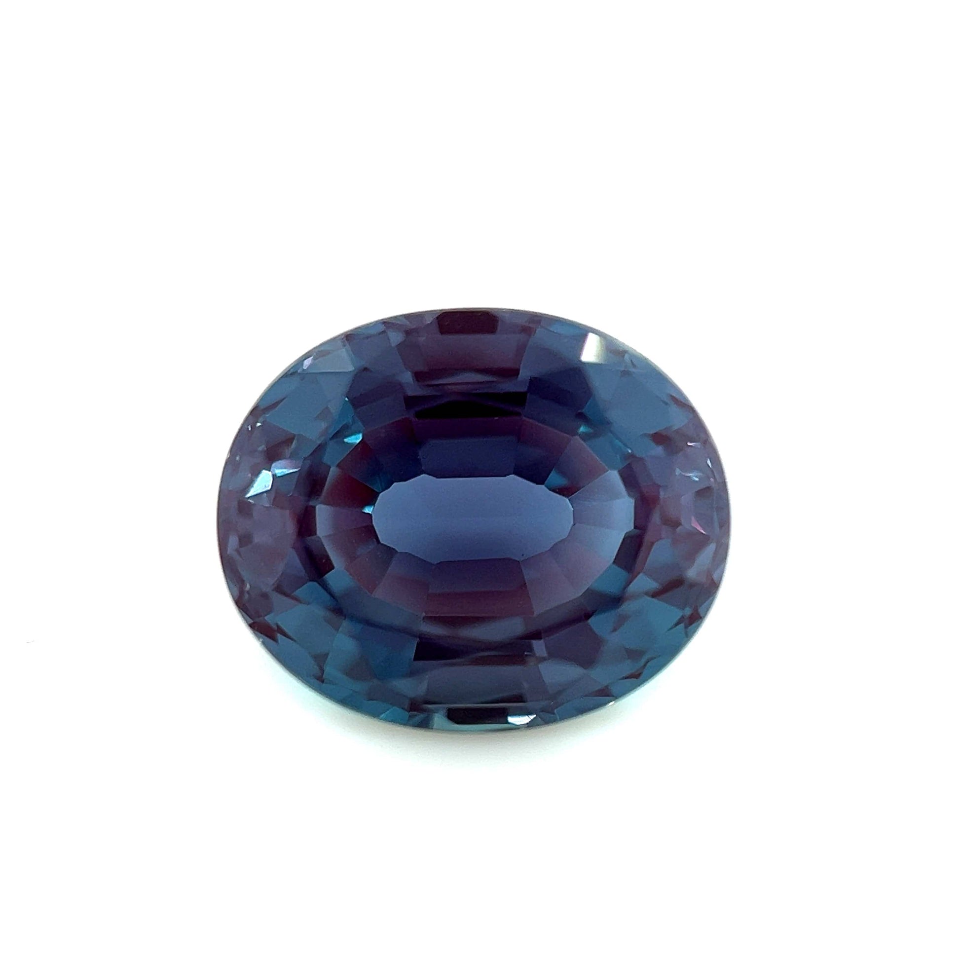 A 12.0x10.0 Exceptional Oval Step Lab Created Alexandrite with deep blue and purple hues is displayed on a white background.