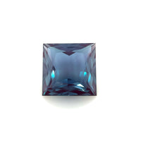 The 8mm Exceptional Square Princess Lab Created Alexandrite, a square-cut gemstone with a deep blue hue and sharp facets, is displayed against a plain white background.