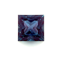 The 9mm Exceptional Square Princess Lab Created Alexandrite shows deep blue and purple hues, with intricate faceting that forms an X-shaped reflection at its center, displayed against a white background.