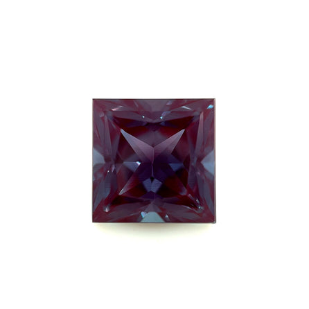 The 10mm Exceptional Square Princess Lab Created Alexandrite features a deep purple hue and intricate facets that reflect light in geometric patterns, set against a plain white background.