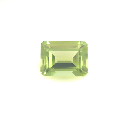 The 8.0x6.0 Premium Emerald Peridot features a natural rectangular cut with sharp facets, displayed against a plain white background.