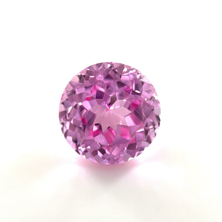 A 10mm Exceptional Round Lab Created Medium Pink Sapphire with a sparkling, faceted surface is displayed against a plain white background.
