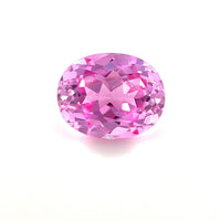 An exceptional 10.0x8.0 oval lab-created medium pink sapphire with a sparkling surface is displayed on a plain white background.