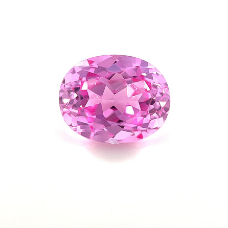 An exceptional 10.0x8.0 oval lab-created medium pink sapphire with a sparkling surface is displayed on a plain white background.