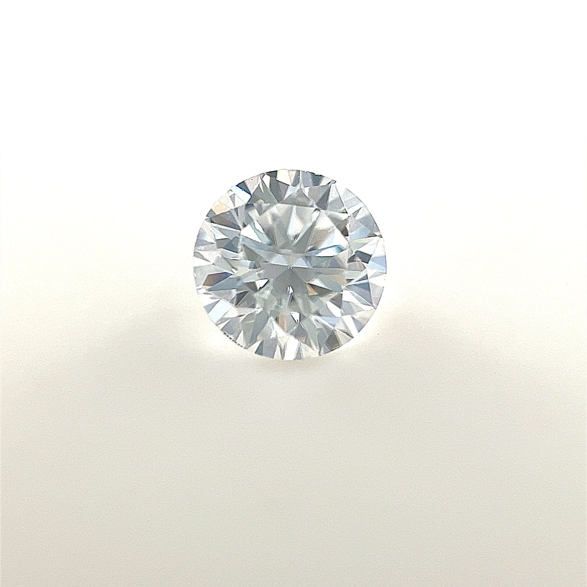 A 5.5mm round white Moissanite is displayed on a plain white background, highlighting its brilliant-cut facets and clear, reflective surface.