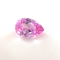 A 9x6 Exceptional Pear Lab Created Medium Pink Sapphire with a faceted surface is shown on a plain white background, highlighting its brilliant reflectivity and vibrant medium pink hue.