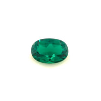 The 9.0x6.0 Exceptional Oval Zambian Color Lab Created Emerald features a faceted, vivid green stone that glows brightly against a plain white background.