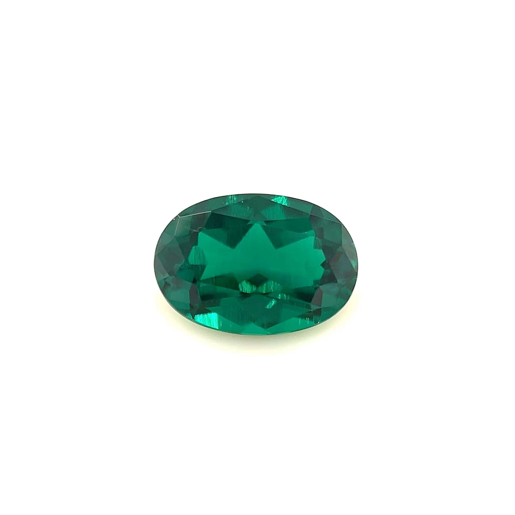 The 10.0x7.0 Exceptional Oval Zambian Color Lab Created Emerald features a faceted, deep green gemstone displayed against a plain white background.