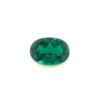 The 10.0x7.0 Exceptional Oval Zambian Color Lab Created Emerald features a faceted, deep green gemstone displayed against a plain white background.