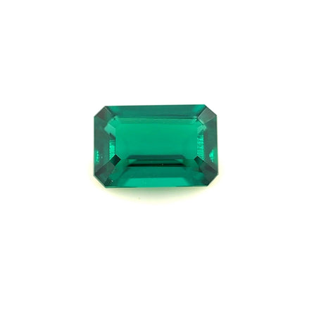 A 9.0x6.0 exceptional Zambian color lab created emerald, emerald-cut with beveled edges, is displayed on a plain white background.