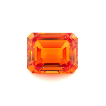 An exceptional 10.0x8.0 emerald-cut lab-created orange sapphire with beveled edges and sharp facets is displayed on a plain white background.