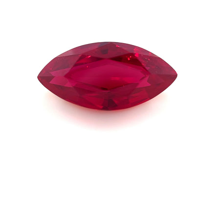 The 12.0x6.0 Exceptional Marquise Step Lab Created Ruby, with its vivid red hue, is beautifully showcased against a white background.