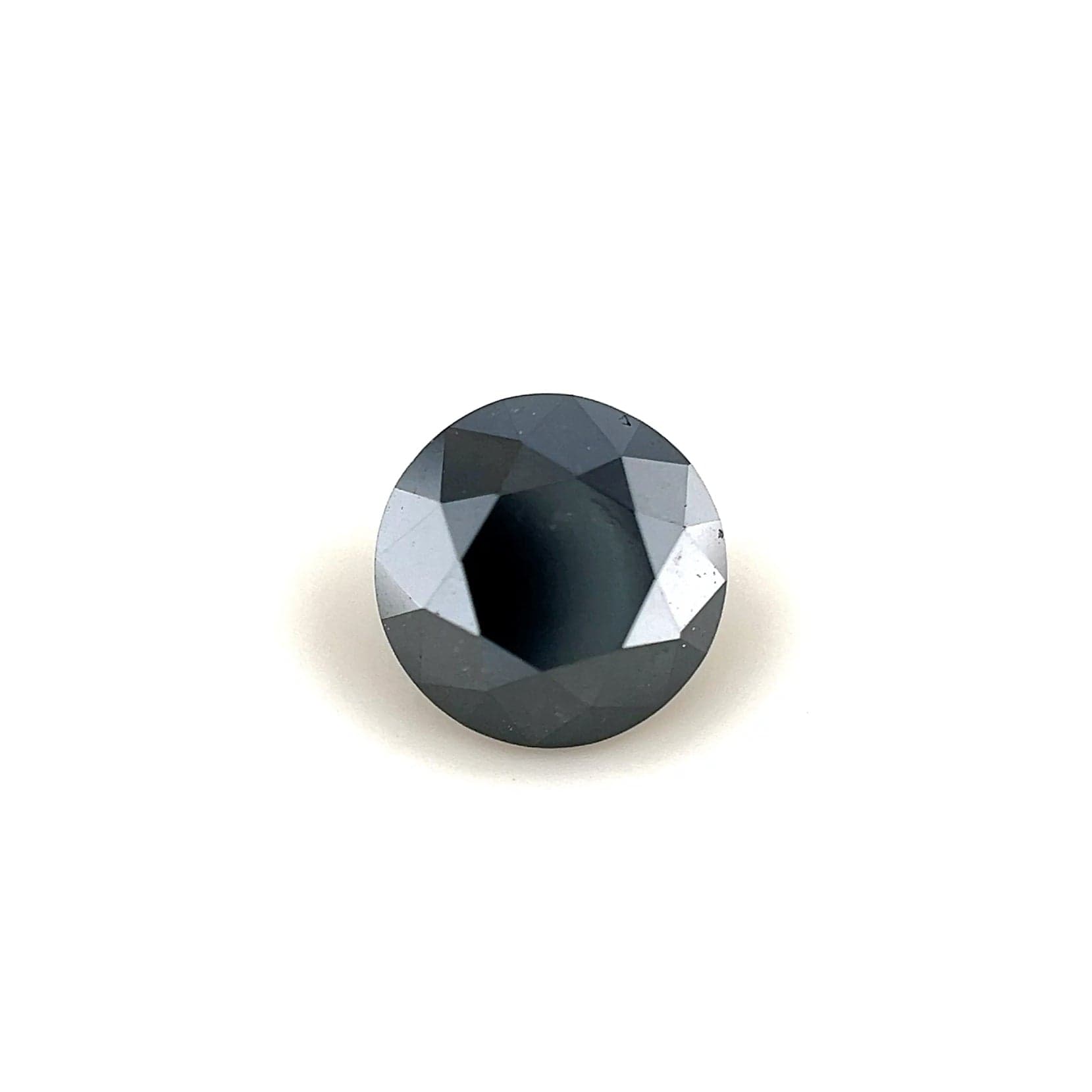 A 1.40 carat, round faceted black diamond (6.65 x 6.65 x 4.87 mm) with a reflective surface is showcased against a plain white background.