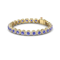 The Tanzanite & Diamond Halo Tennis Bracelet - Isabella features round blue tanzanites, each set in an individual bezel and surrounded by sparkling diamonds, finished with a secure clasp.