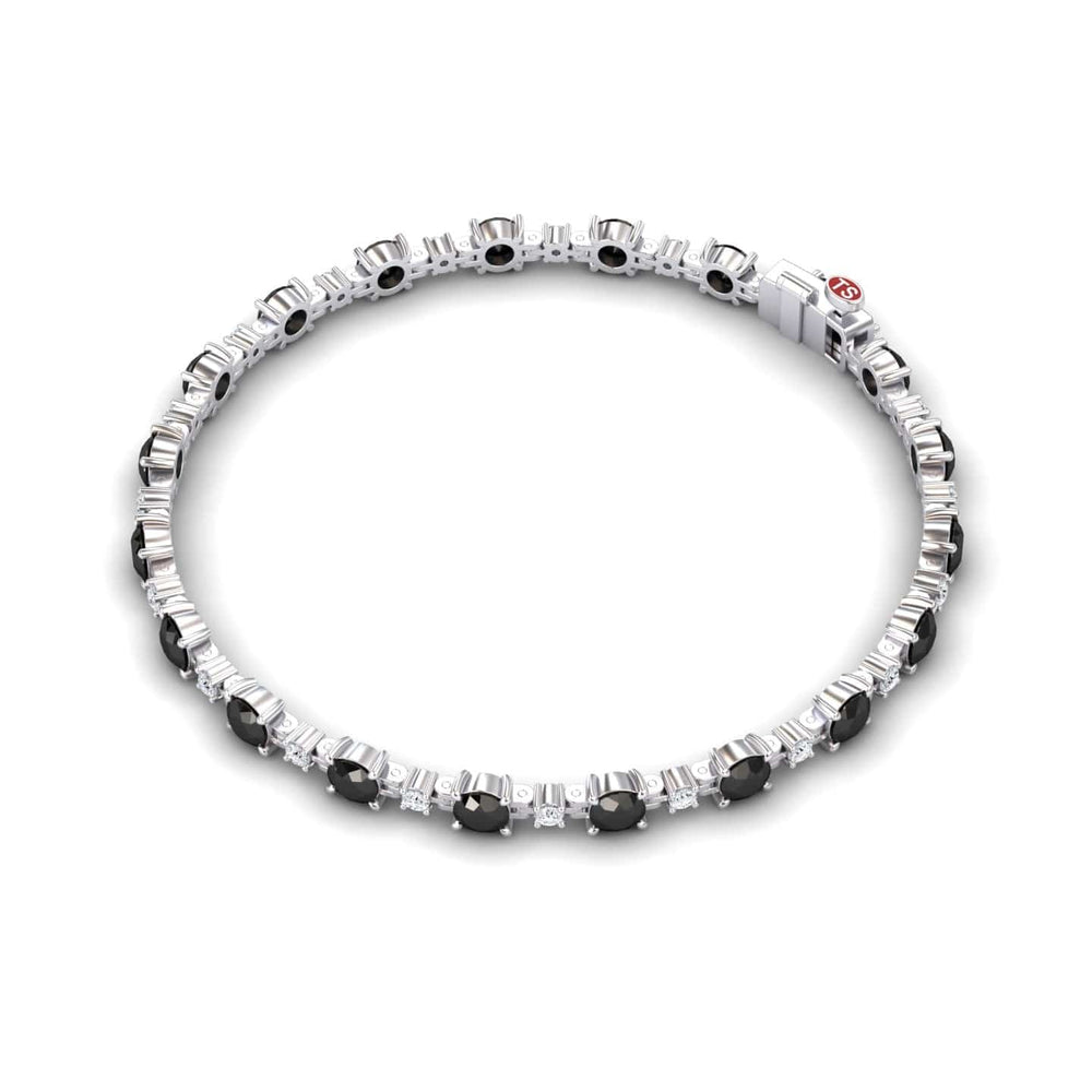 The Black & White Diamond Tennis Bracelet - Natalia features alternating round black and clear gemstones set in silver, evenly spaced along the length, and finished with a sleek clasp.