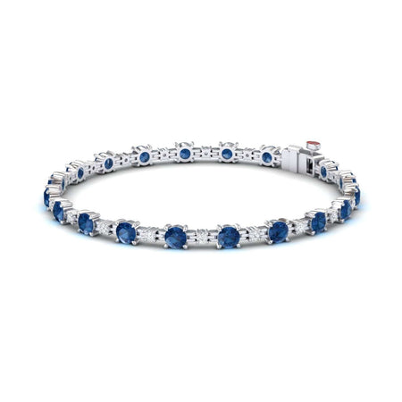 The London Blue Topaz & Diamond Tennis Bracelet - Natalia features round blue gemstones in prong settings, shown on a white background.