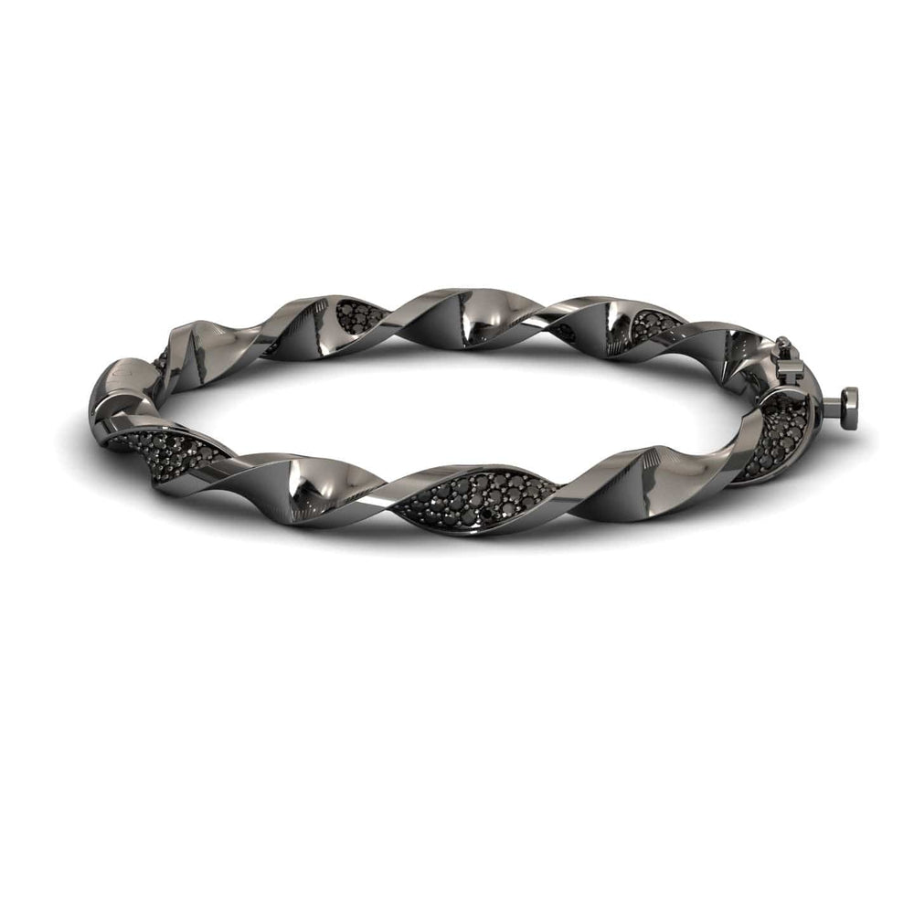 The Black Diamond Twisted Bangle Bracelet - Dakota features a sleek metallic design with embedded dark stones, a twisted motif, and a secure clasp for an elegant, modern look.