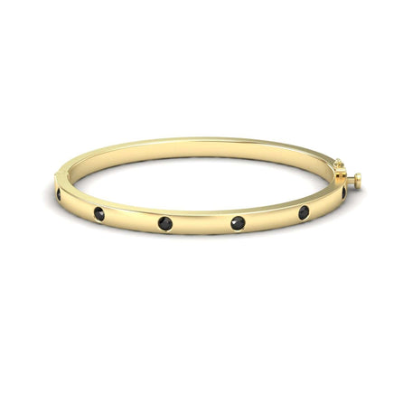 The Black Diamond Bezel-Set Bracelet - Flavia features evenly spaced black gemstones set in gold, displayed against a plain white background.