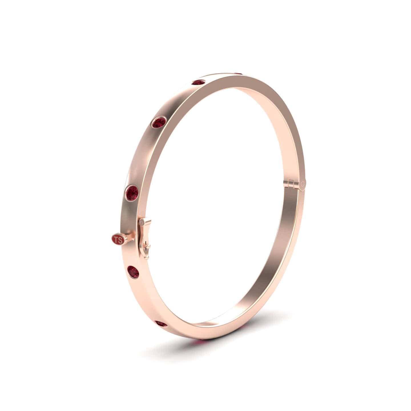 The RUBY Bezel-Set Bracelet - Flavia is a slim rose gold bangle adorned with evenly spaced red gemstones, shown against a plain white background.