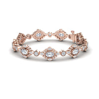 The Ariana White Sapphire & Diamond Vintage-Inspired Tennis Bracelet showcases sparkling round and oval gems in ornate settings, combining rose gold with intricate patterns for a timeless, elegant look.