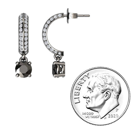 The Black & Diamond Pave Drop Hoop Earrings - Serena, featuring black stones and clear crystals, are shown beside a 2020 US dime for size comparison. These small hoops offer a modern, sparkly design.