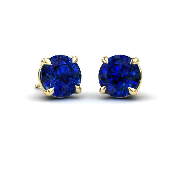 A pair of lab grown blue sapphire stud earrings set in gold mounting.