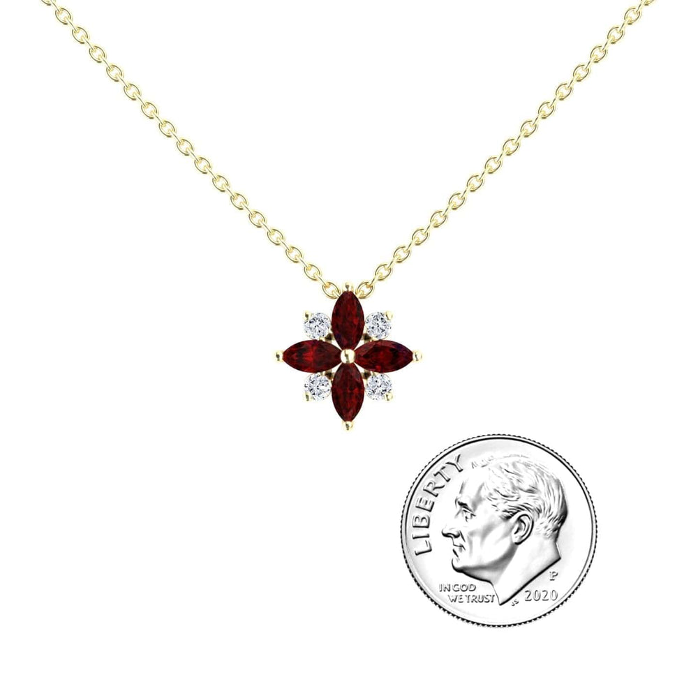 The Ruby & Diamond Flower Necklace - Keira features a gold chain with a flower pendant of four marquise red stones and four small white stones, shown beside a 2020 U.S. dime for size reference.