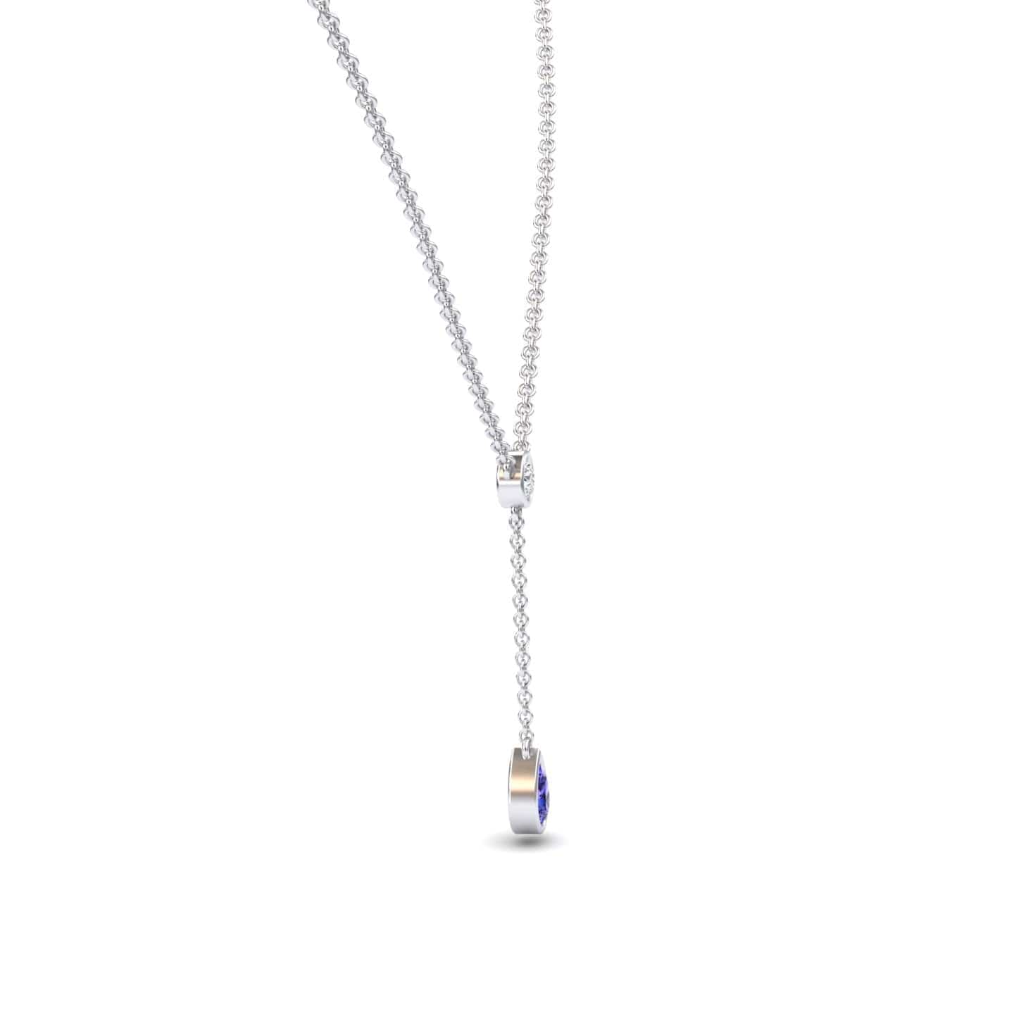 The Tanzanite & Diamond Elegant Drop Necklace - Daniela features a delicate silver chain with a sliding clasp and a vertical drop ending in a small, round tanzanite and diamond pendant. Displayed on a plain white background.