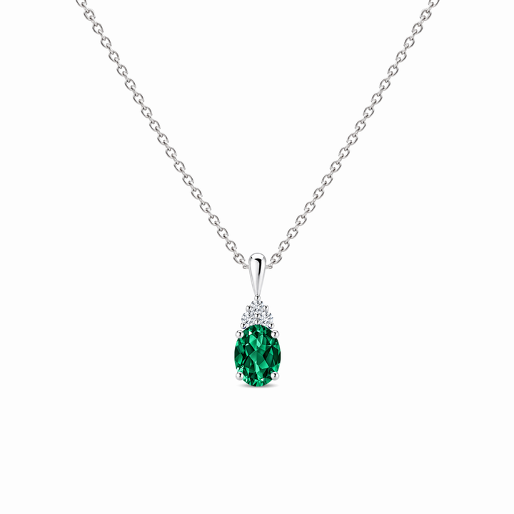 Lab-grown emerald and trio diamond oval solitaire necklace in 14k white gold