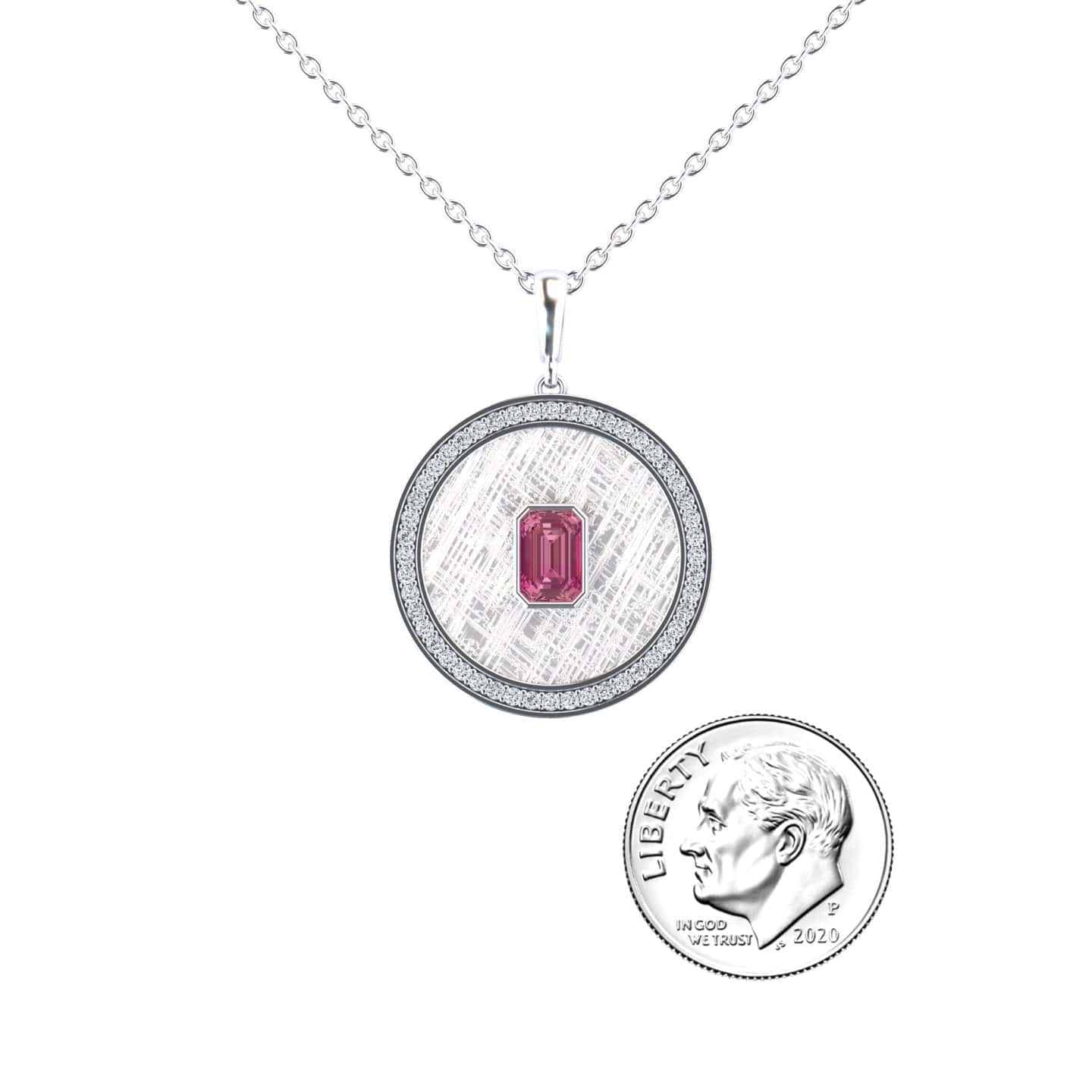 The Pink Tourmaline & Diamond Textured Medallion Necklace - Jasmine features a round silver pendant with a pink tourmaline gemstone at the center, shown beside a U.S. dime for size reference.