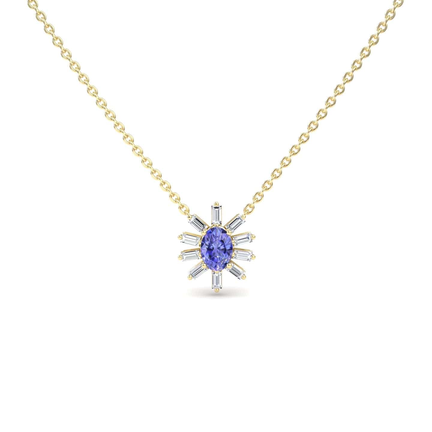 The Tanzanite & Diamond Starburst Necklace - Laura features a gold chain with a central oval blue gemstone and radiating baguette-cut clear stones in a starburst design, displayed against a white background.