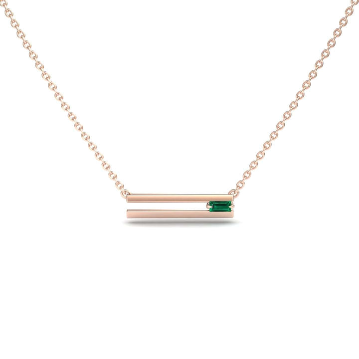 The Emerald Bar Necklace - Cecilia is a delicate rose gold necklace with two horizontal bars, the top bar set with a small rectangular green gemstone, displayed against a plain white background.