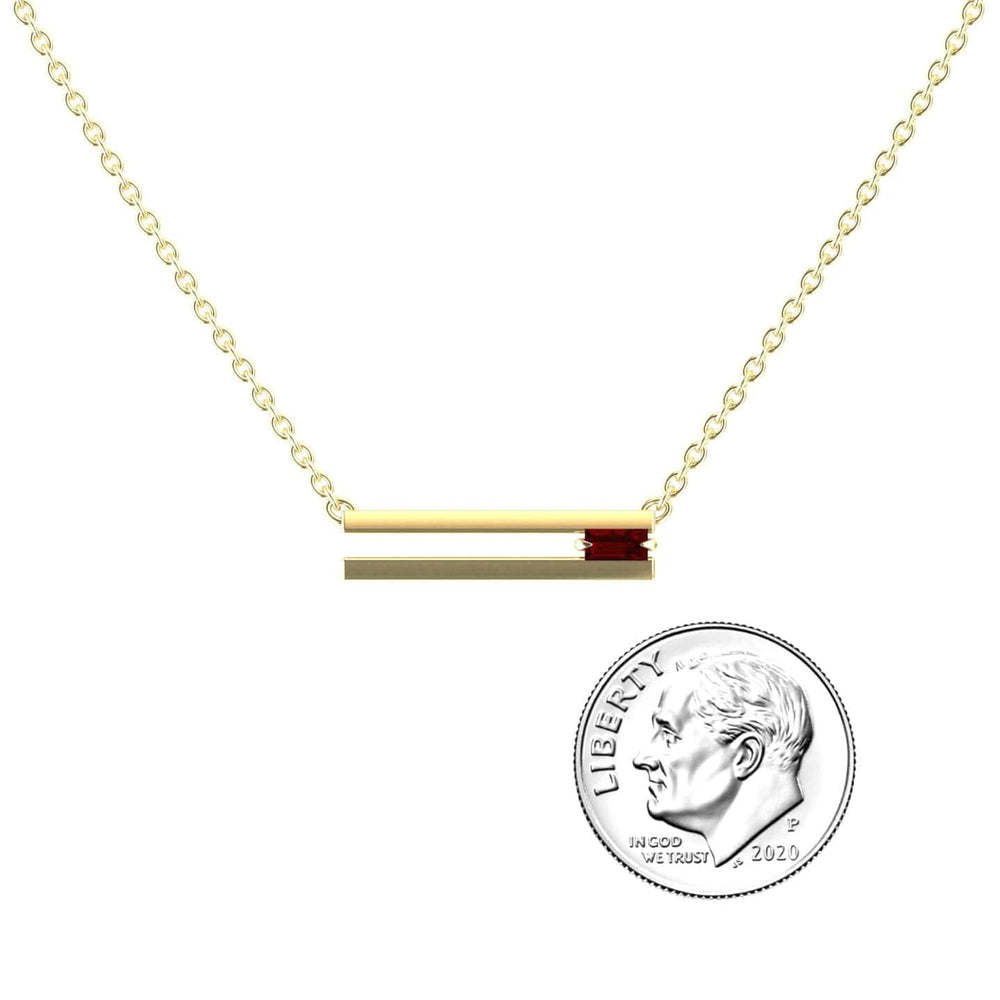 The Garnet Bar Necklace - Cecilia features a delicate gold chain with a horizontal gold bar pendant accented by a small red garnet. A U.S. dime is shown next to the pendant for size reference.