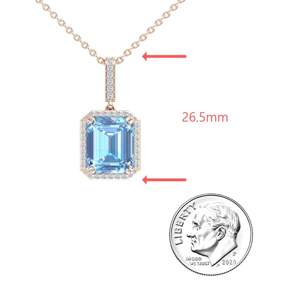 The Sky Blue Topaz & Diamond Halo Necklace - Sanya features a rectangular blue topaz pendant with a diamond halo, shown beside a 2020 U.S. dime for scale and an arrow marking its 26.5mm length.
