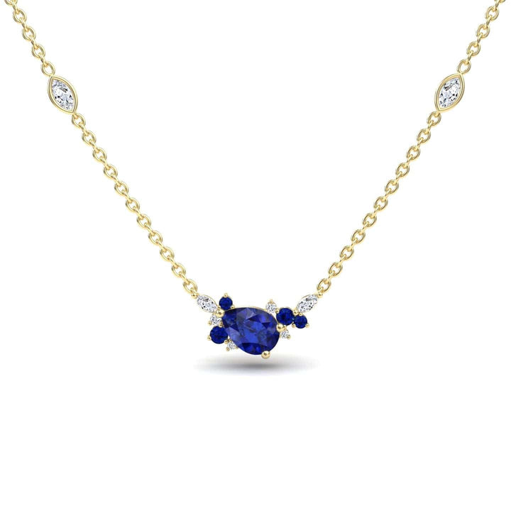The Blue Sapphire & Diamond Bouquet Necklace - Daria features a gold chain with a central pear-shaped blue gemstone, accented by small blue and white stones and two marquise-cut white stones along the chain.