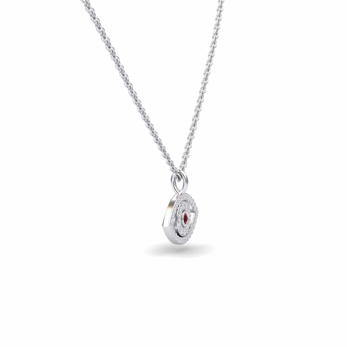 The Ruby & Diamond Eye Necklace - Elise is a silver necklace with a round, textured pendant featuring a central red gemstone and small clear stones, shown against a plain white background.