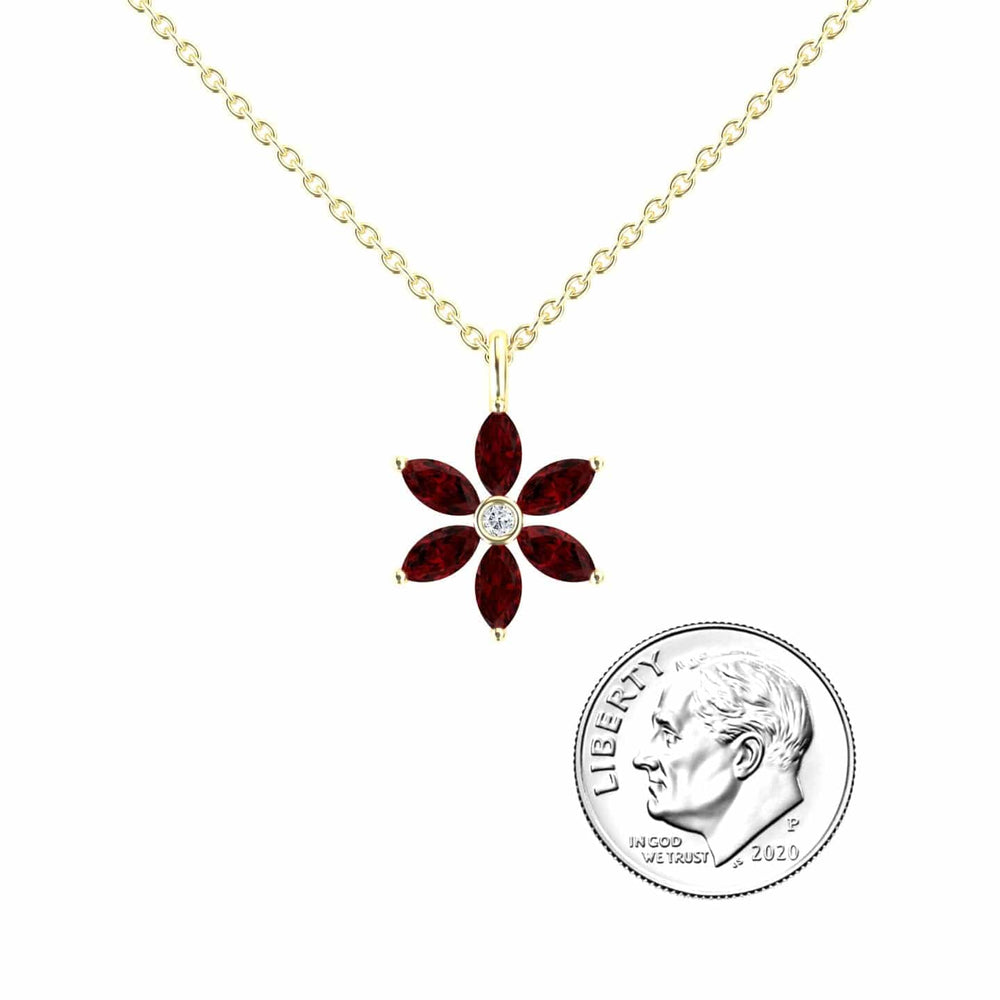 The Lab Grown Ruby & Diamond Floral Necklace - Erin features a gold chain with a flower-shaped pendant of six marquise-cut red stones and a central clear stone, shown beside a 2020 US dime for scale.