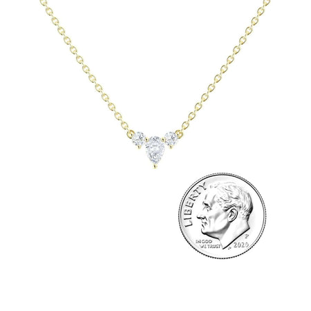 The White Diamond Three-Stone Necklace - Jina features a gold chain with three small clear stones at the center, shown beside a 2020 US dime for size reference.