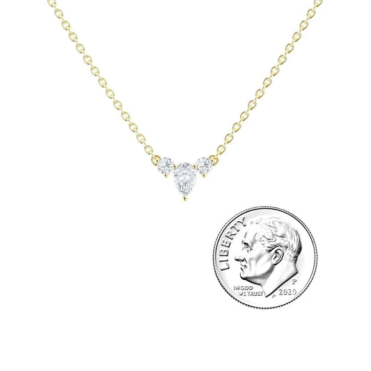 The White Diamond Three-Stone Necklace - Jina features a gold chain with three small clear stones at the center, shown beside a 2020 US dime for size reference.