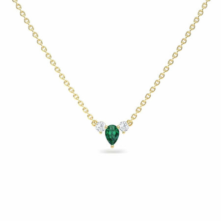 The Emerald & Diamond Three-Stone Necklace - Jina features a gold chain with a pear-shaped green gemstone pendant accented by two small round white gemstones on each side, shown against a white background.
