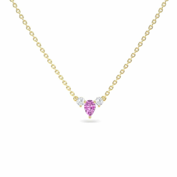 The Pink Sapphire & Diamond Three-Stone Necklace - Jina showcases a pear-shaped pink sapphire pendant centered on a gold chain, accented by two round diamonds on each side, displayed against a plain white background.