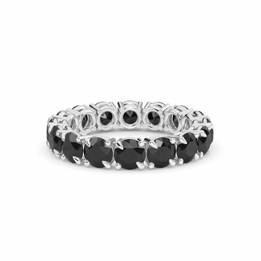 The Black Diamond Prong Set Eternity Band - Mehak features a continuous row of round black diamonds in a silver band, showcased against a white background.