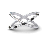 The Black & White Diamond Crossover Ring - Gracie features two intersecting silver bands, one plain and one set with alternating black and white diamonds, elegantly displayed on a white background.