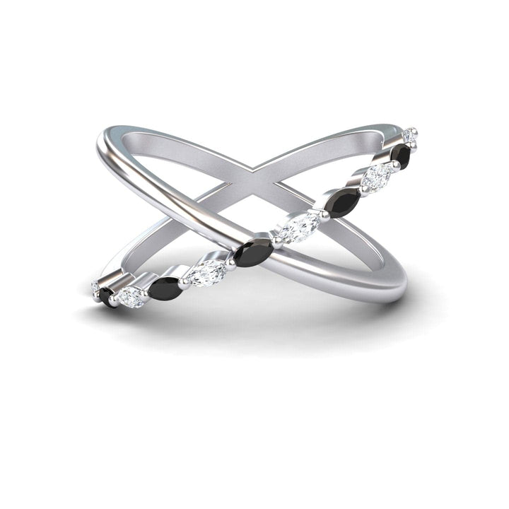 The Black & White Diamond Crossover Ring - Gracie features two intersecting silver bands, one plain and one set with alternating black and white diamonds, elegantly displayed on a white background.