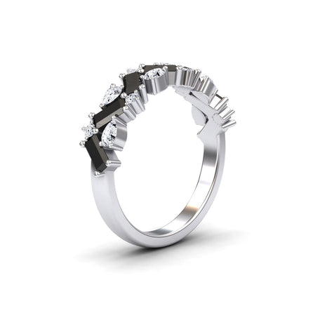 The Aimee Black & White Diamond Zigzag Eternity Band features alternating black and clear gemstones in a sleek zigzag pattern on a silver band, creating a modern, elegant look against a plain white background.